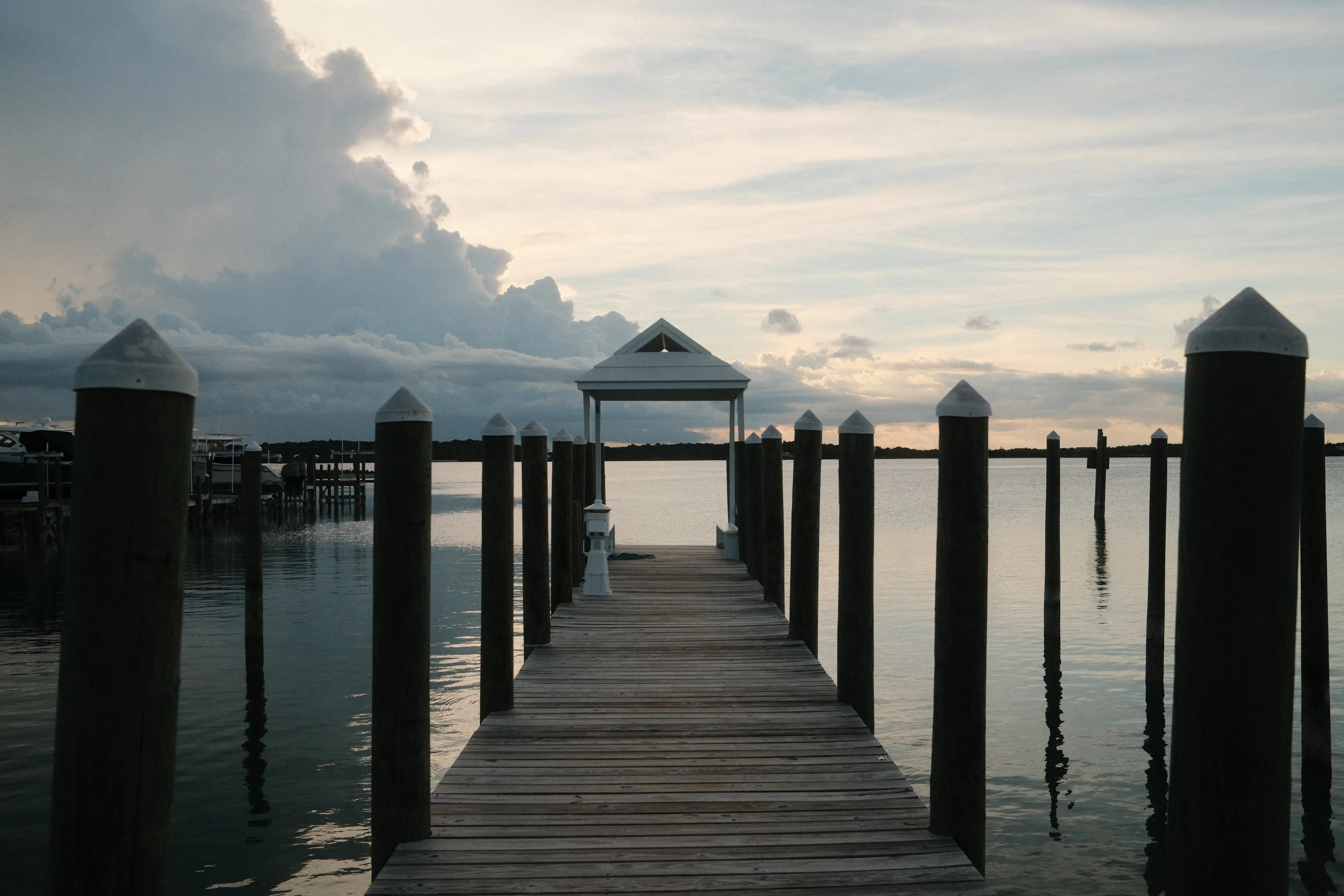 The jetty running out into flat water at dusk.