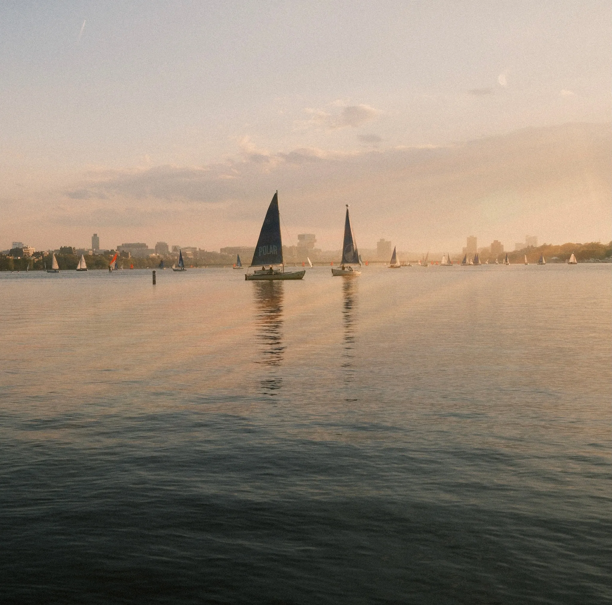 Dinghies out on the river with the skyline behind.